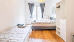 Een slaapkamer met een bed, een kledingkast en een raam met gordijnen.
