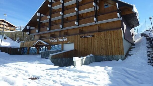 A wooden lodge with a sign reading "STARS PHOTO". - 100m from resort center, 1st floor, balcony, tv, 25m², Alpe d'Huez (L'Alpe d'Huez)