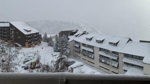 A snow-covered building with multiple floors and balconies, surrounded by snow-covered trees and parked cars. - 80m from shops, 3rd floor, tv, ski locker, 24m², Alpe d'Huez (L'Alpe d'Huez)