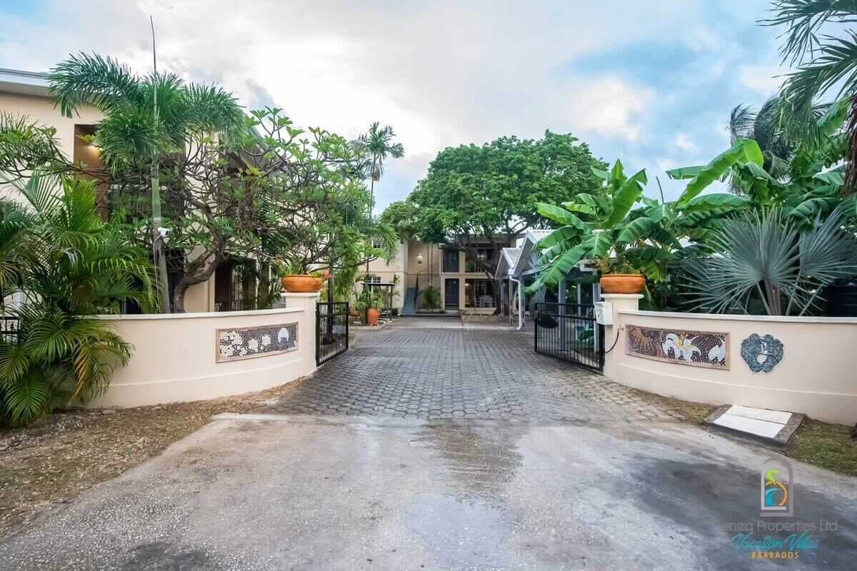 A paved entrance to a property with a tiled pathway leading to a building.