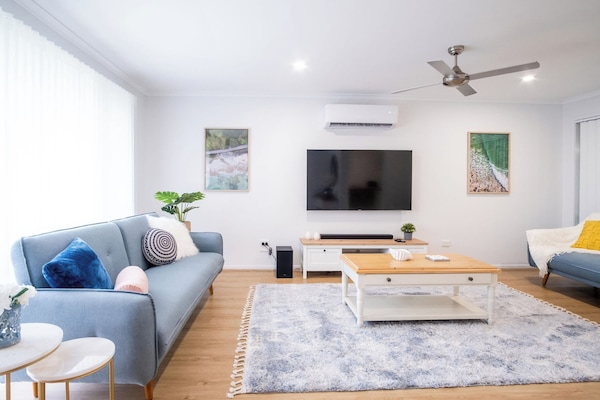 Softly decorated lounge room with plenty of comfy seating.