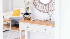 A room with a white desk, a mirror, and a yellow pillow.