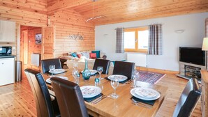 A wooden cabin with a dining area, kitchen, and living space. - Osprey Lodge (Lincoln)