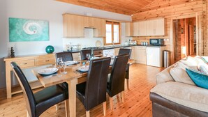 A wooden interior with a dining area, kitchen, and living space. - Osprey Lodge (Lincoln)