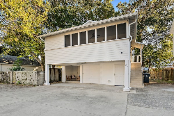 A two-story house with a garage, a covered porch, and a staircase leading to the upper level.