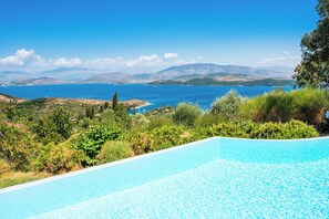 Piscina con vistas a un paisaje costero y montañas.