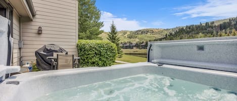 Un jacuzzi con vista a una zona residencial y colinas.