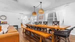 Un espace repas avec une table et des bancs en bois, entouré de chaises en osier.