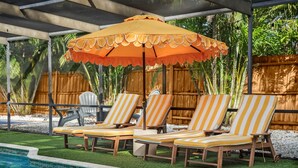 A poolside area with lounge chairs and a canopy. - Massive Beach House, 6BR 8BA, Heated Pool, Pickleball, Hot tub, Gym, Sleeps 22 (Bradenton)