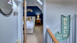 A bedroom with a bed, a nightstand, a lamp, and a wall-mounted light fixture.