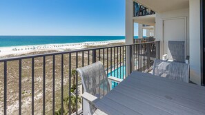 A balcony with a view of the beach and a pool. - Gorgeous 3 Bedroom Unit Phoenix VI 6715 (Orange Beach)