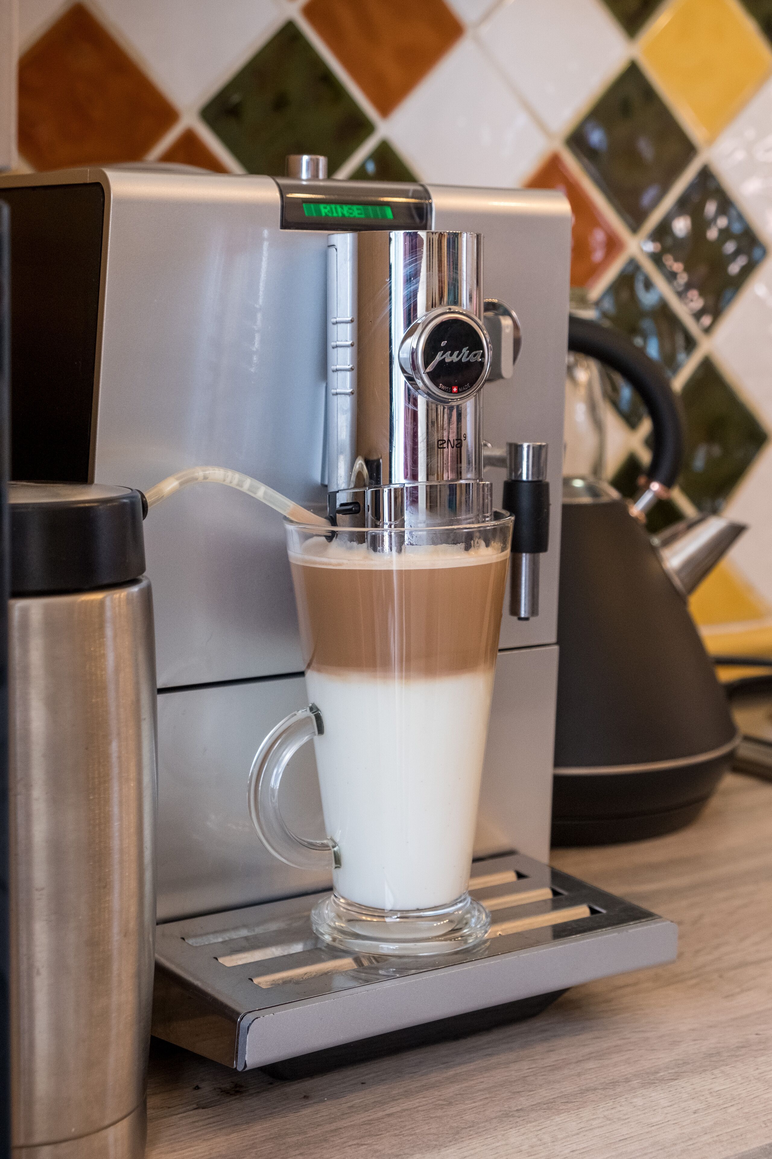 Una máquina de café vertiendo leche en una taza.