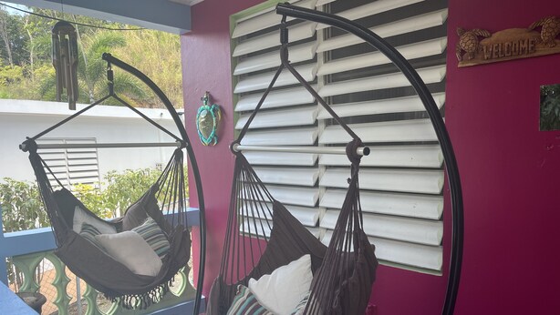 Two hammocks suspended from a balcony railing, with a 'Welcome' sign and a decorative turtle carving on the wall. - Peaceful, fully renovated home that is solar powered!   (Rincon)