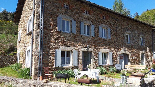 A stone building with multiple windows and a patio area with outdoor furniture. - Grande Ourse guest room (SEMBADEL)