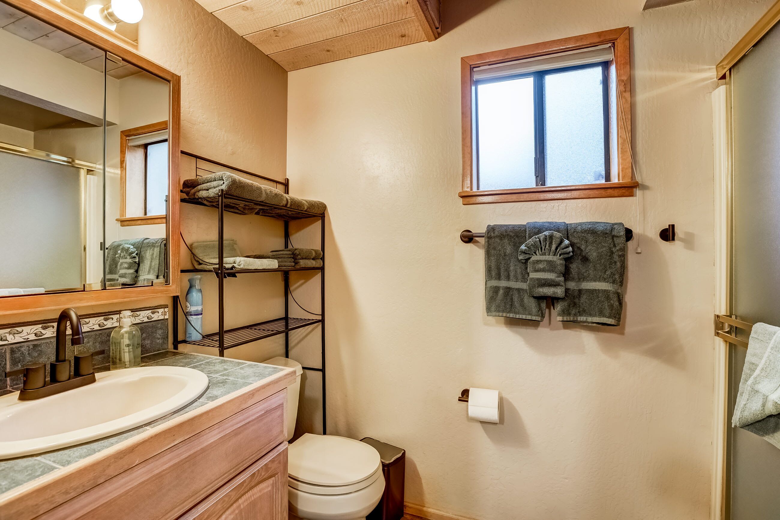 Un baño con lavamanos, inodoro y ventana.