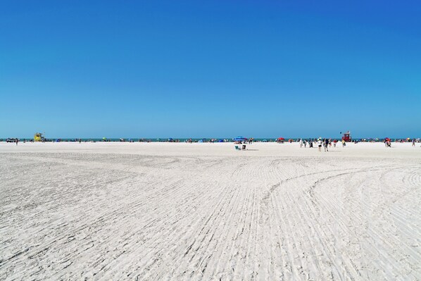 A wide sandy beach with clear blue skies.