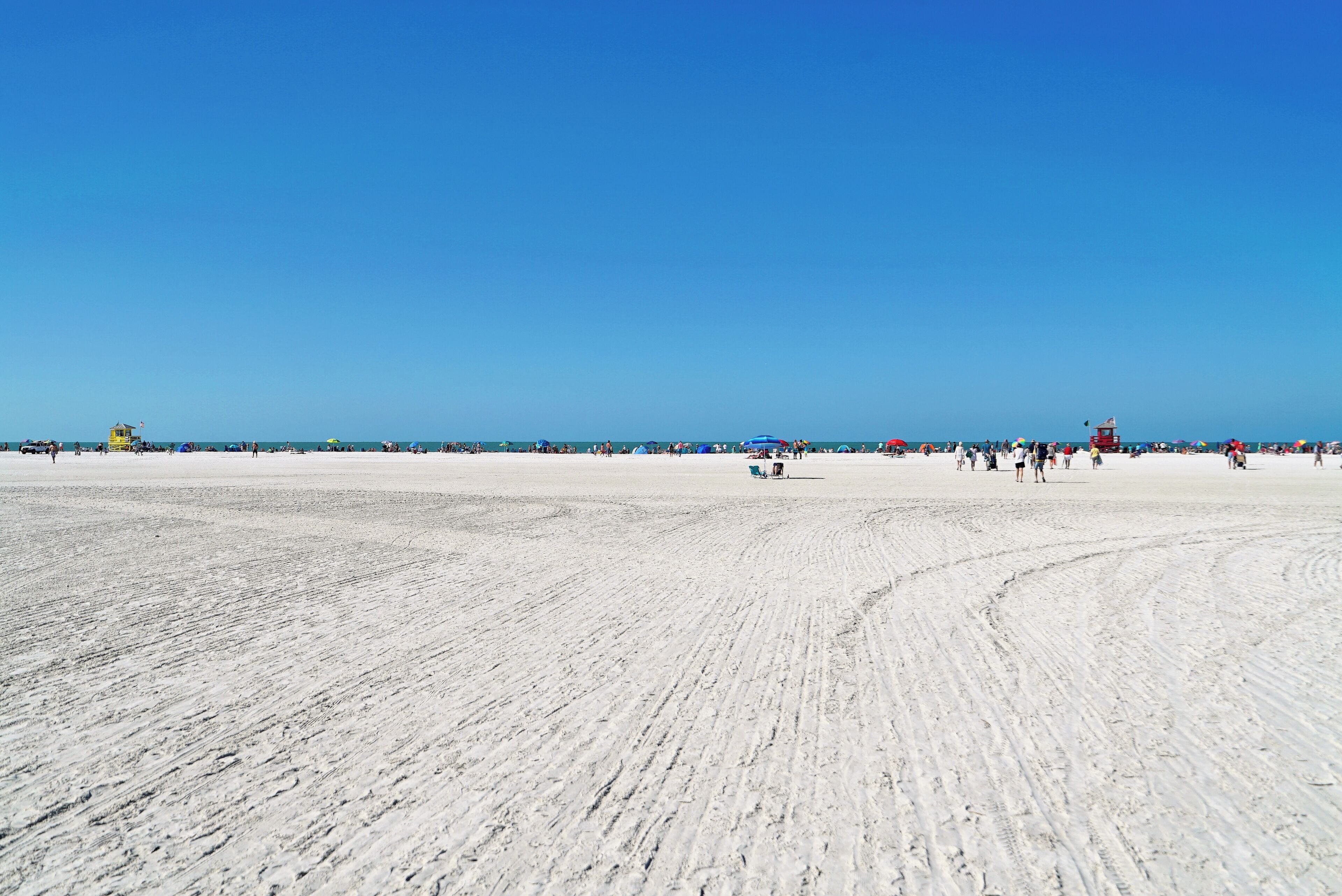 A wide sandy beach with clear blue skies.