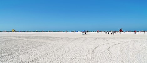 A wide sandy beach with clear blue skies.