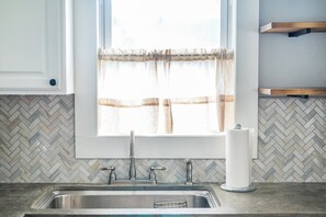 Een bad/douchecombinatie, een haardroger, handdoeken, zeep