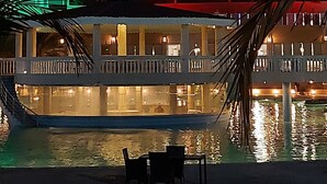 A hotel with a pool area, featuring a sign in Arabic and English, and a red building facade. - Al Salam Grand Hotel & Resort (Al Buraymi)