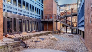 A modern building with a courtyard, featuring a staircase, large windows, and a mix of brick and metal construction. - Park City Ski Trip - Lift Line Condo Hot Tub (Park City)