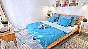 Une chambre à coucher avec un lit, des tables de chevet, un bureau et une chaise.