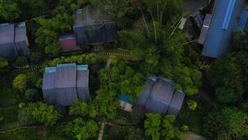 An aerial view of a residential area with multiple houses surrounded by dense greenery.