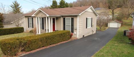 A single-story house with a front porch, a garage, and a driveway.