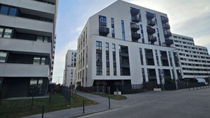 A modern building with multiple floors, large windows, and balconies.