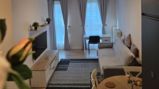 A compact living space with a bed, a desk, and a dining area.