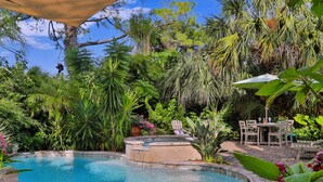 A swimming pool surrounded by lush greenery, a hot tub, and a patio area with outdoor furniture. - Tranquil Guest Suite in Paradise with Private Pool Walking Distance to Town
 (Saint Augustine)