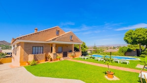 Une maison à deux étages avec une piscine, une pelouse bien entretenue et une vue dégagée sur le paysage environnant.
