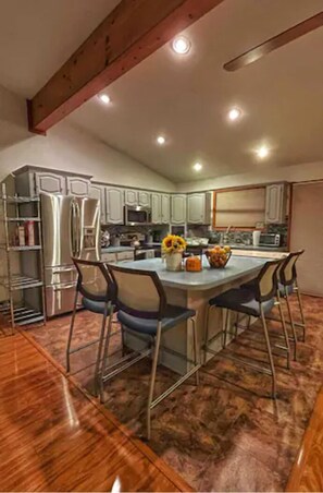 Enjoy cooking in this well-equipped kitchen with a central island, stainless steel appliances, and ample cabinetry.