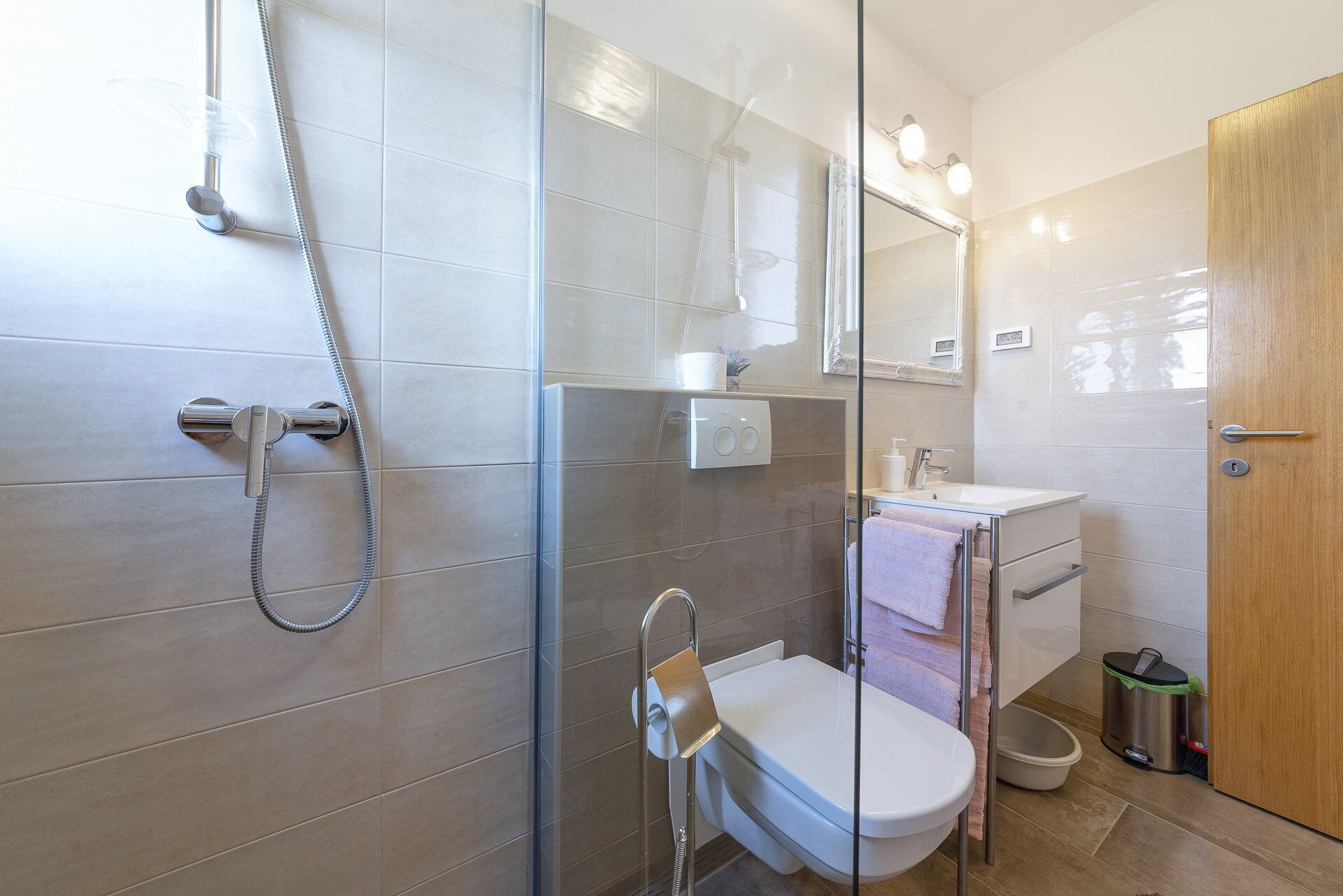 Une salle de bain moderne avec une douche à parois de verre, des toilettes et un lavabo.