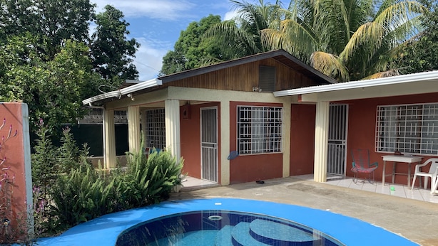 A two-story building with a swimming pool in the foreground. - Walk to beach and many shops in Playas del Coco , Costa Rica (Playas del coco)