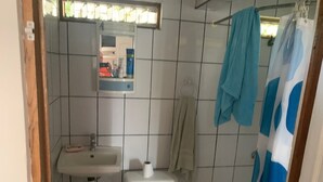 A small bathroom with a white sink, toilet, and a mirror above the sink. - Walk to beach and many shops in Playas del Coco , Costa Rica (Playas del coco)