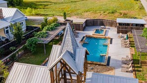 A pool area with a wooden deck, a hot tub, and lounge chairs. - Luxury Carlton Landing Home Golf Cart Included! (Carlton Landing)