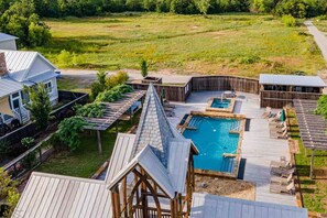 A residential property with a swimming pool, wooden deck, and a fenced garden area.