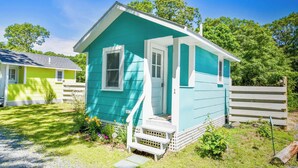 A small, single-story house with a porch and a front door. - Cozy Colorful Cottage Perfect for 2! (Eastham)