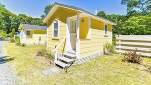 A yellow single-story house with a porch and steps leading to the entrance. - Dreamy Cottage for Two! Close to Beaches! (Eastham)