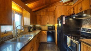 A compact kitchen with wooden cabinets, a stainless steel sink, a microwave, a refrigerator, and a stove. - RMNP,Longs Peak Views,Fireplace,Grill,Deck,Mtn Neighborhood Above Estes Park (Estes Park)