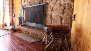 A stone wall, a radiator, a wooden stool, and a wooden floor. - RMNP,Longs Peak Views,Fireplace,Grill,Deck,Mtn Neighborhood Above Estes Park (Estes Park)