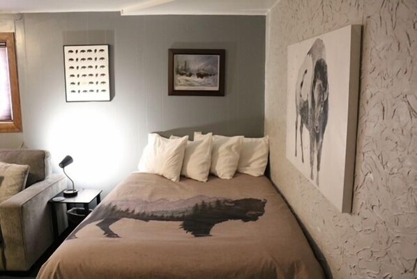 A bedroom with a bed, a nightstand, a lamp, and a framed picture on the wall. - RMNP,Longs Peak Views,Fireplace,Grill,Deck,Mtn Neighborhood Above Estes Park (Estes Park)