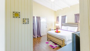 Hotelkamer met een houten bed, een bureau, een stoel, een kledingkast en een plafondventilator.