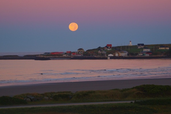 moon rise and sun sets behind the house