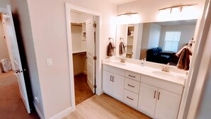 A modern bathroom with a large mirror, two sinks, and a walk-in closet. - Escondido Luxury Resort, pool, slide, pickleball, 4 bedrooms, bunks, 2car garage (Washington)