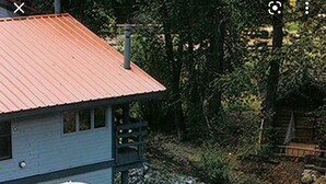 Ein zweistöckiges Haus mit einer Holzterrasse, einem Schwimmbad und einer überdachten Terrasse.