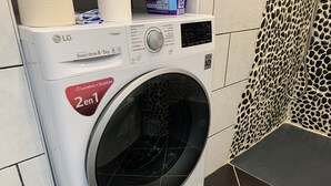 Una lavatrice LG bianca con inverter e motore a trasmissione diretta, capacità 8/5 kg, con un adesivo rosso che indica una funzione 2-in-1.