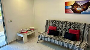 Un soggiorno moderno con un divano, un tavolino e una parete decorata con arte astratta.