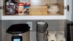 A kitchen with a coffee maker, a coffee grinder, and a tea set on the counter. - Lakefront 3 Bedroom house with breath taking views (Agoura Hills)